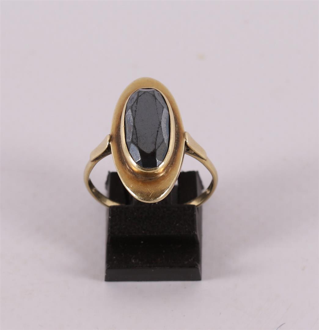 A 14 kt 585/1000 yellow gold entourage ring, set with oval faceted garnet, gross weight 3.8 grams,
