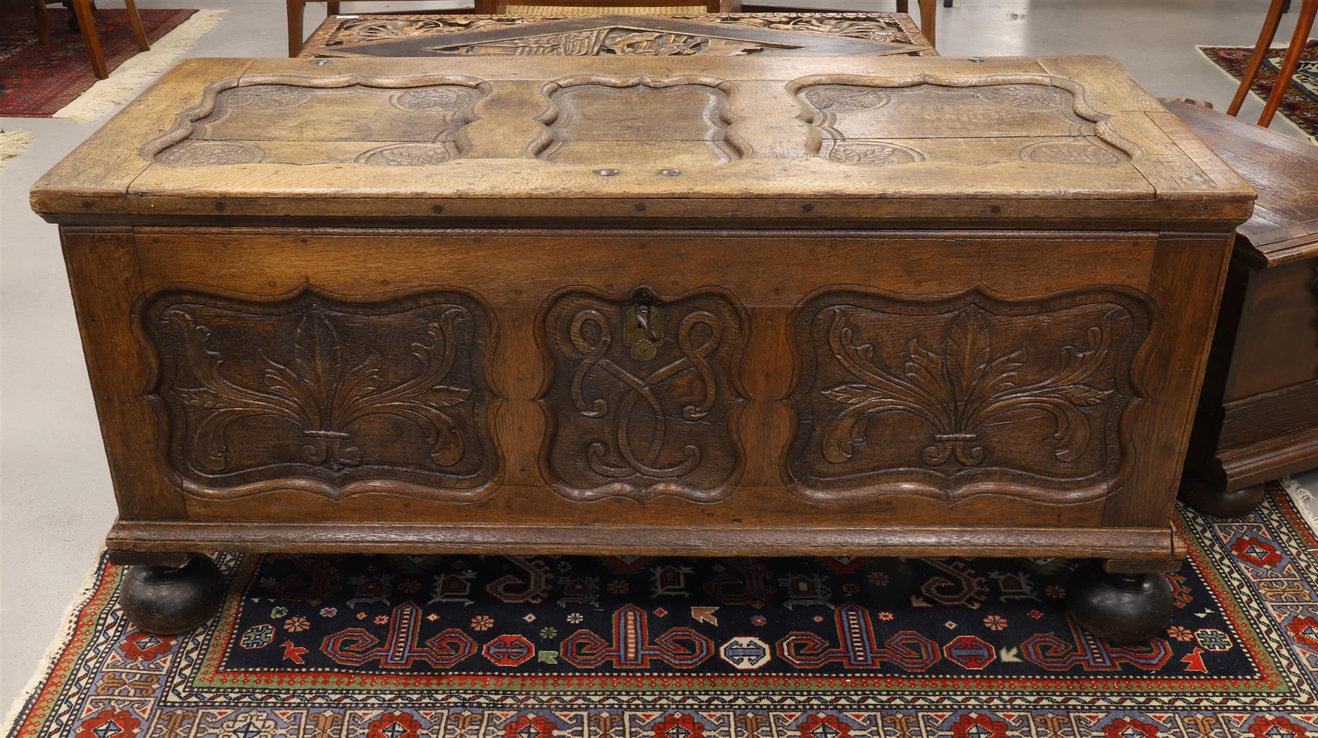 A blanket chest with flat lid, 18th century. Oak wood, lid with contoured panels, front with carving