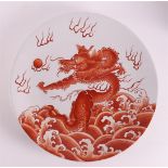 A porcelain 'rouge de fer' dish, China 20th century. Decor of dragon with flaming pearl, marked on