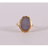 A 14 kt 585/1000 yellow gold entourage ring, set with cabochon cut oval opal, gross weight 3.9