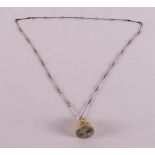 A 1st grade 925/1000 silver necklace and pendant with carved bone, depicting a lion and an