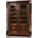 A bookcase in Renaissance style, around 1900. Straight profiled hood with carved acanthus and vase