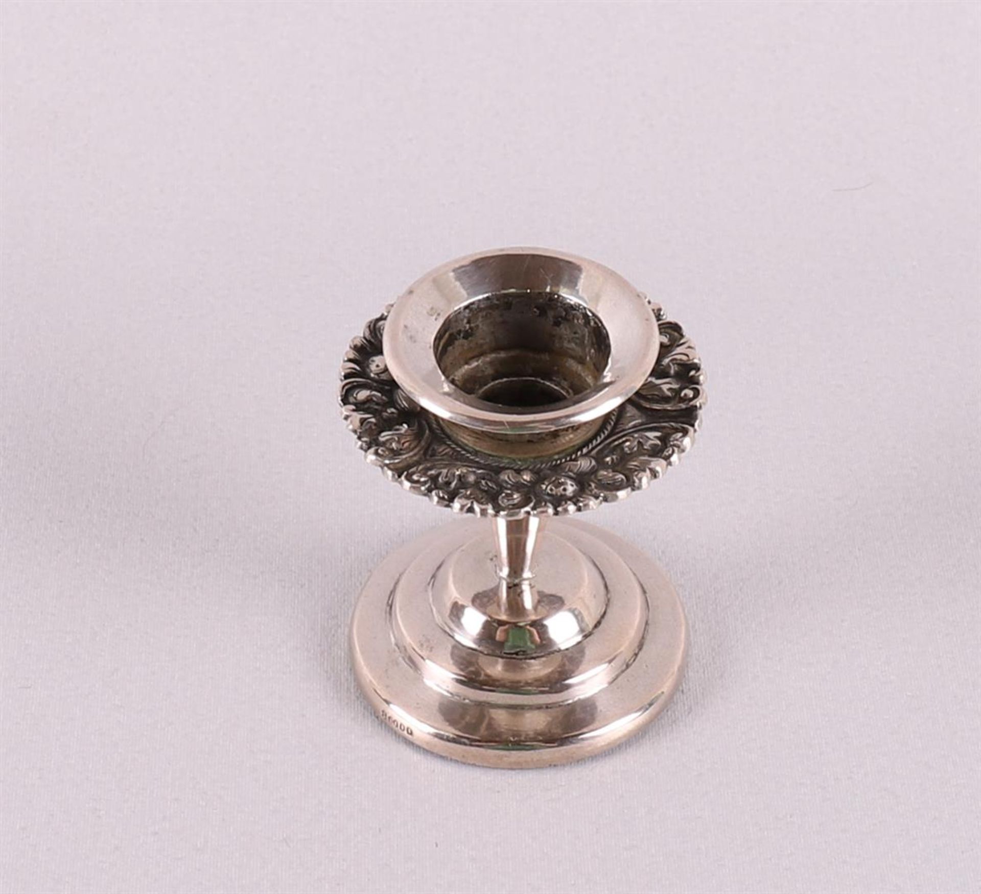 A 3rd grade 800/1000 silver 1-light candlestick with floral decor.