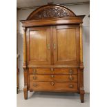 A two-door cabinet, Northern Netherlands, early 19th century. Oak wood, curved profiled hood with