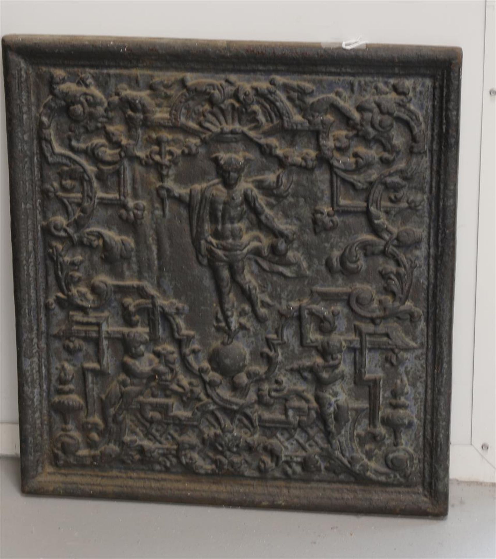 A cast iron fireback, 18th century. Relief decoration of figures and flora, h 55 x w 50 cm.