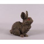 A brown patinated bronze rabbit with red glass eyes, Japan, 20th century, h 10 x l 11 cm.