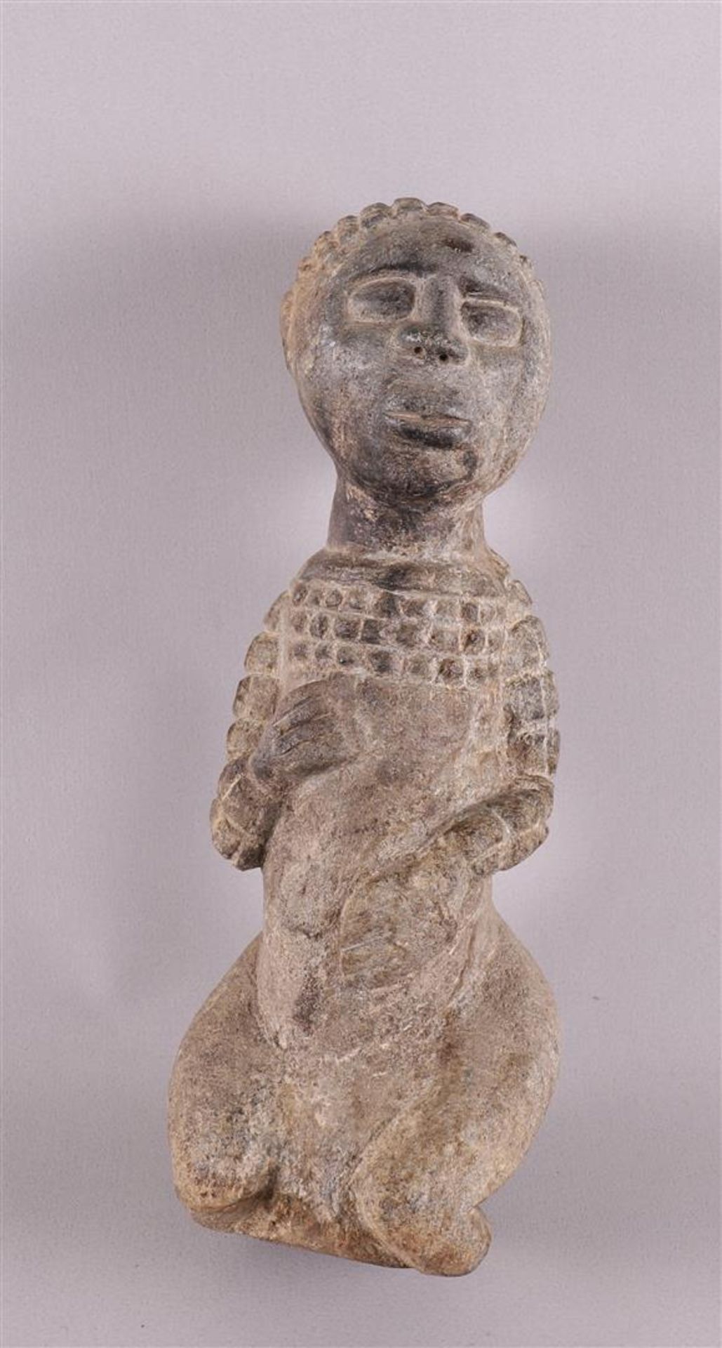 Ethnography. A stone ancestral statue of a kneeling woman, Africa, 20th century, h 34 cm.