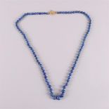 A necklace of lapis lazuli beads with a hammered 14 carat 585/1000 gold clasp and a safety chain.