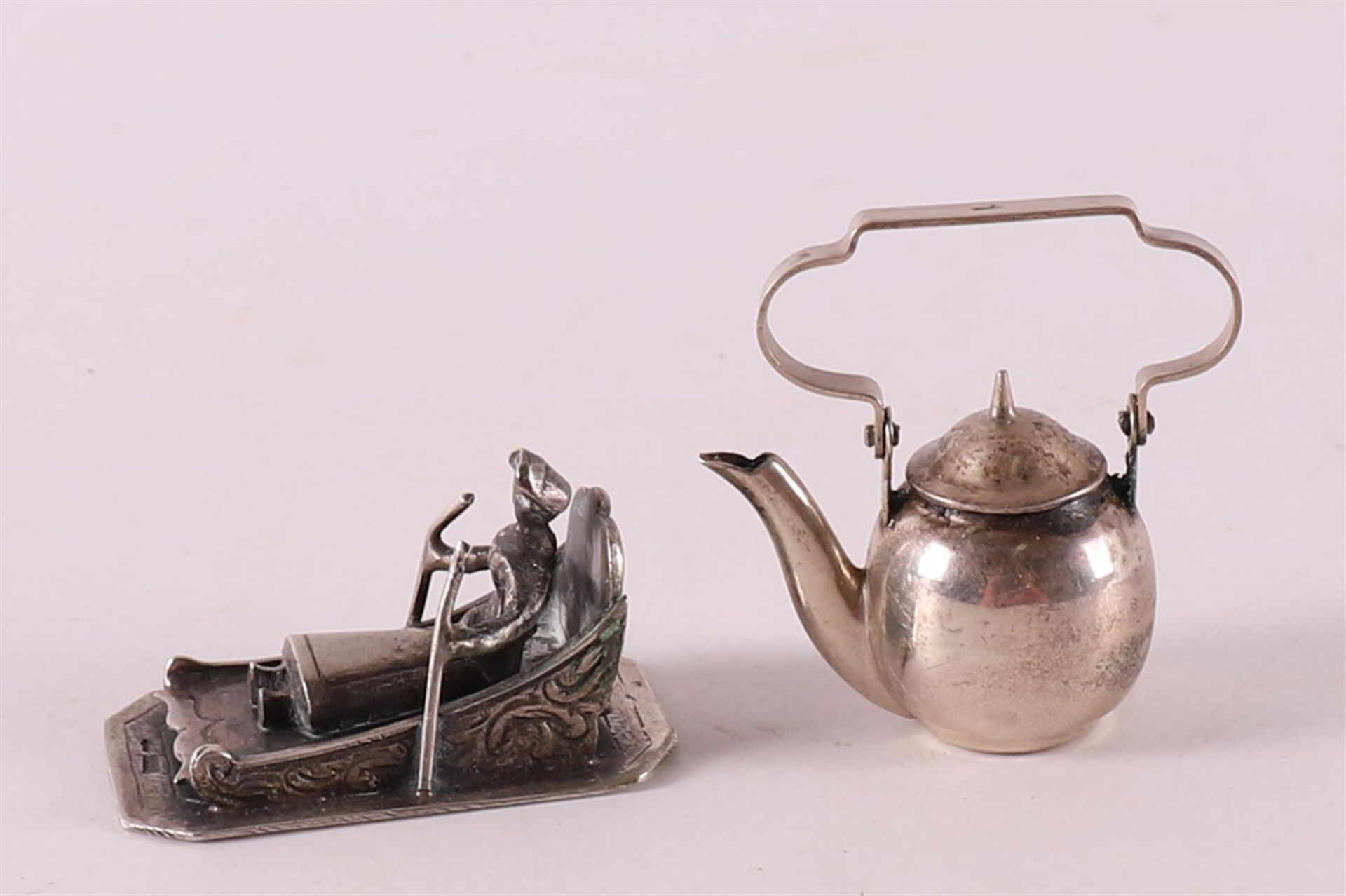 Etagere silver. A kettle and a figure on a spiked carriage, 20th century, tot. 2x.
