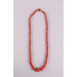 A necklace of red corals, increasing in size from 5 to 12 mm, with a 14 kt 585/1000 gold hammered