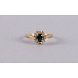An 18 carat 750/1000 gold ring with an oval faceted blue sapphire and an entourage of 14 brilliants.