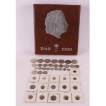 A coin album Juliana 1948-1980 containing many coins, including 10 silver guilders, 7 silver