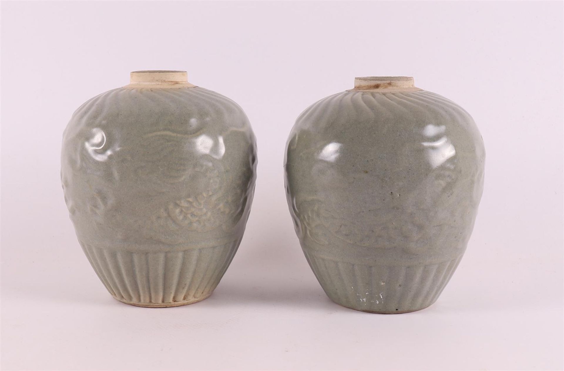 A pair of celadon glazed porcelain vase, China, 20th century or earlier. Relief decoration of dragon