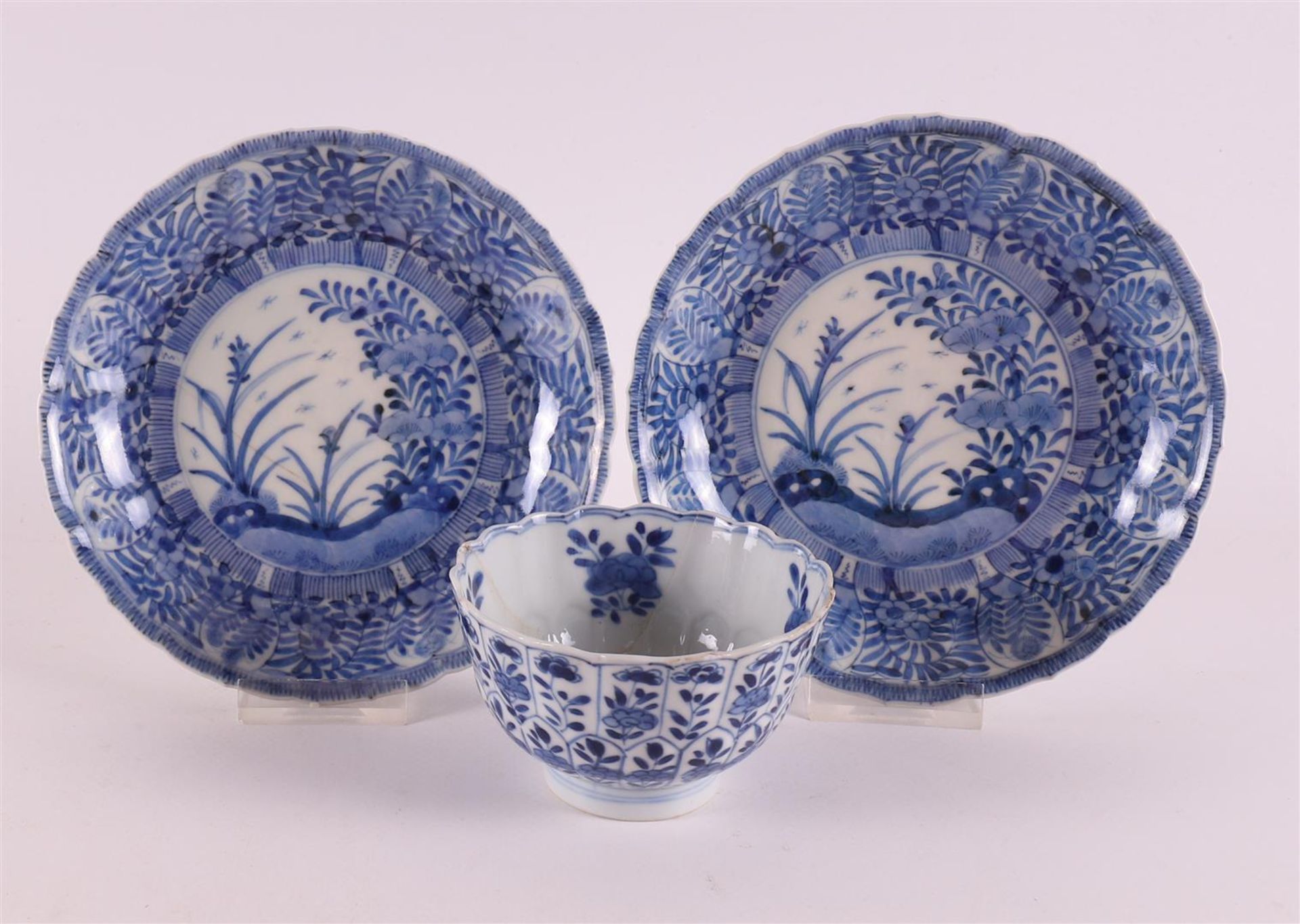 A blue and white porcelain contoured cup and two saucers, China, 19th century. Blue underglaze