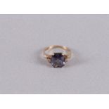 A 10 kt BWG ring with a facet cut purple sapphire and 2 topazes. Ring size 17 mm.
