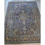 An Oriental carpet with blue background and polychrome floral motifs, wear, made in Iran, length 388