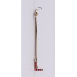 A 14 kt 585/1000 gold and platinum brooch in the shape of a golf stick, set with a diamond and 6