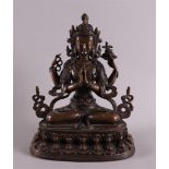 A brown patinated bronze seated Buddha on a lotus crown, India, around 1900, h 22 cm.