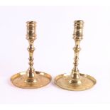 A pair of brass button candlesticks, England, 17th century. Cylindrical candle mouth with rings,