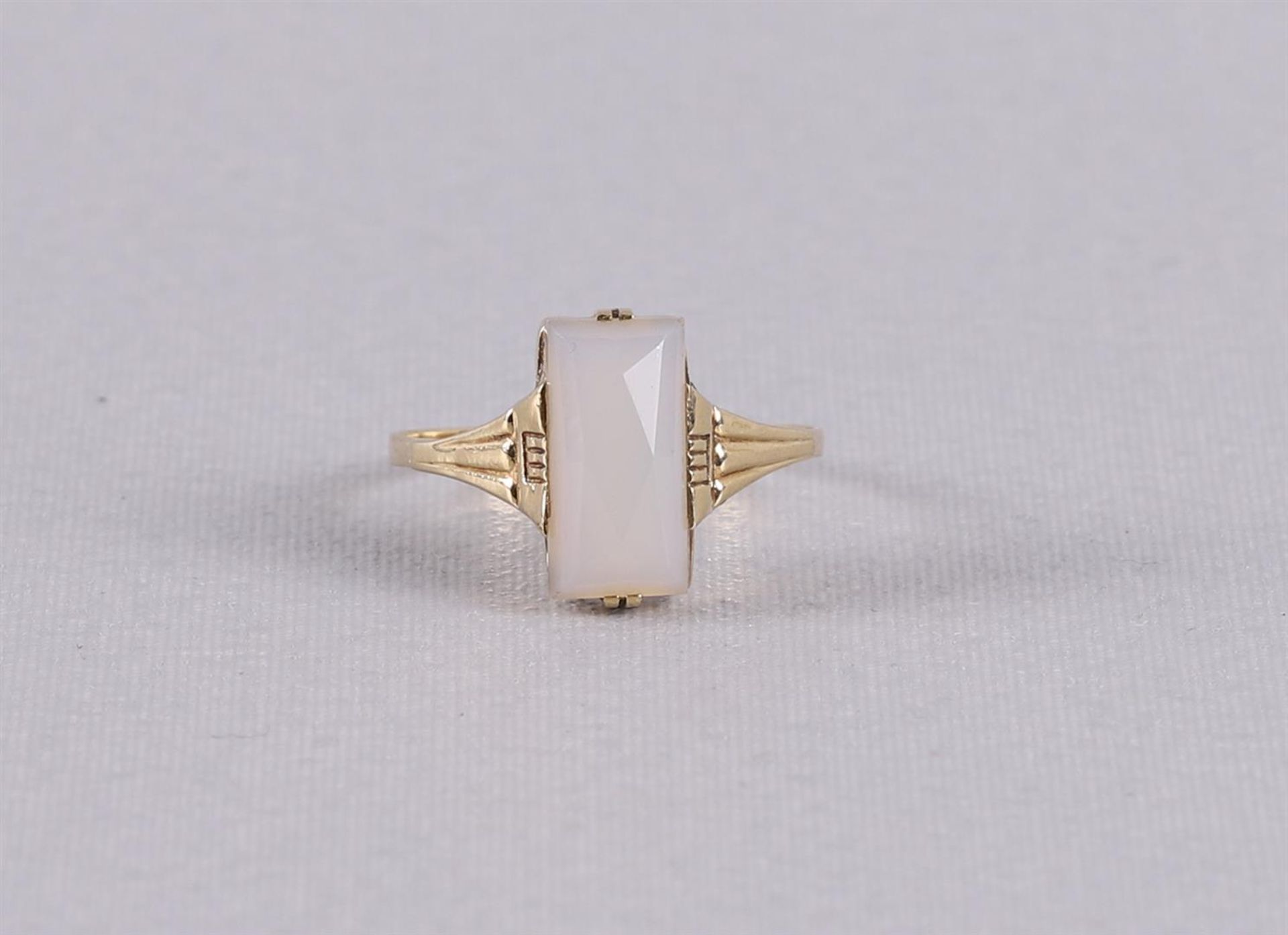 A 14 kt 585/1000 gold Art Deco ring with a facet cut light gray stone. Ring size 18.5 mm.
