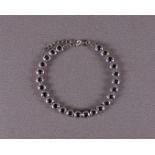 A 1st grade silver tennis bracelet with facet cut blue stones.