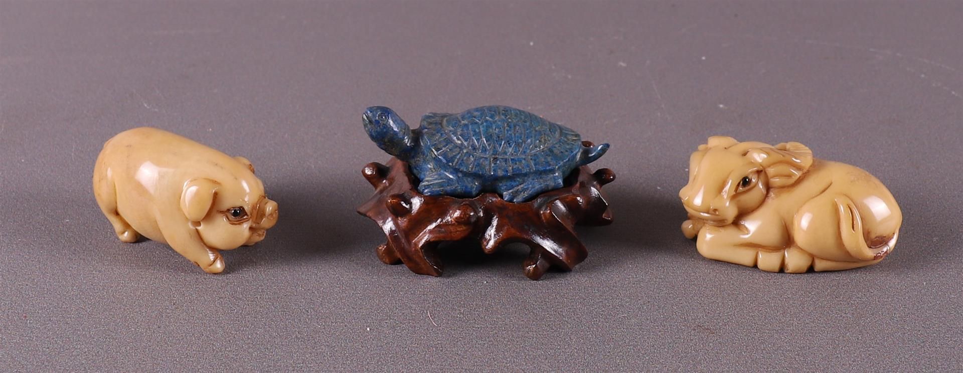 A lapis lazuli netsuke of a turtle on a loose wooden base, Japan.