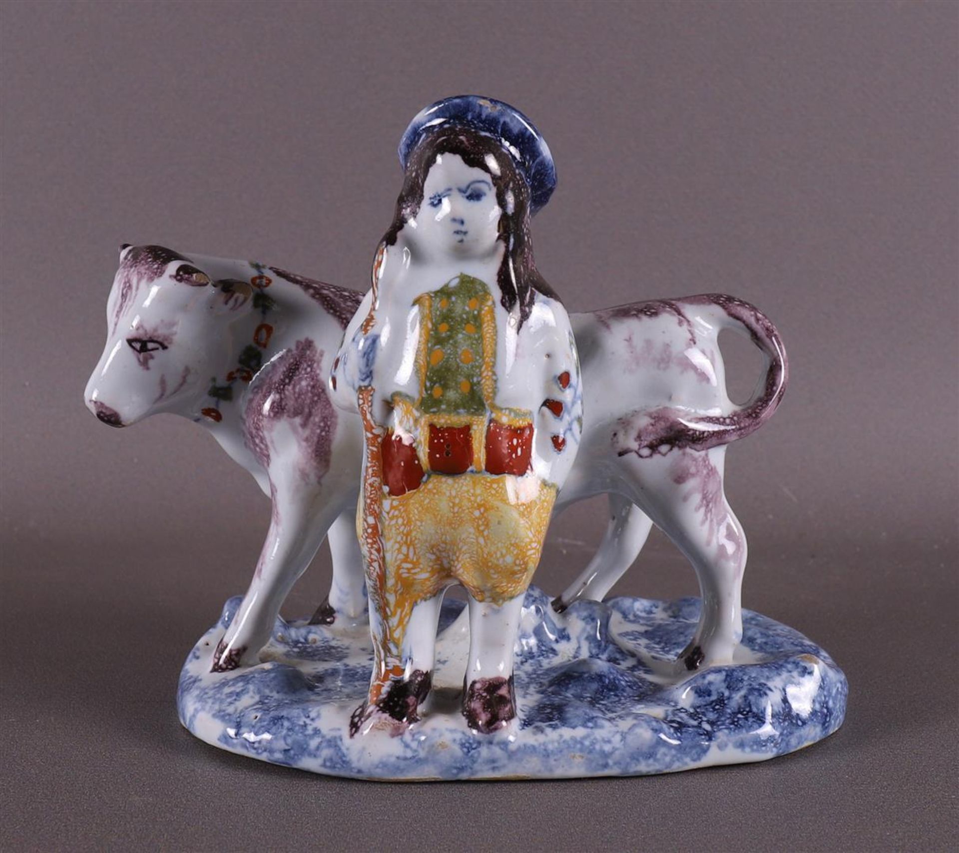 A polychrome Delft earthenware farmer with a cow, 20th century.