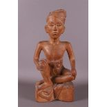 A carved wooden seated man, Indonesia, Bali, 20th century