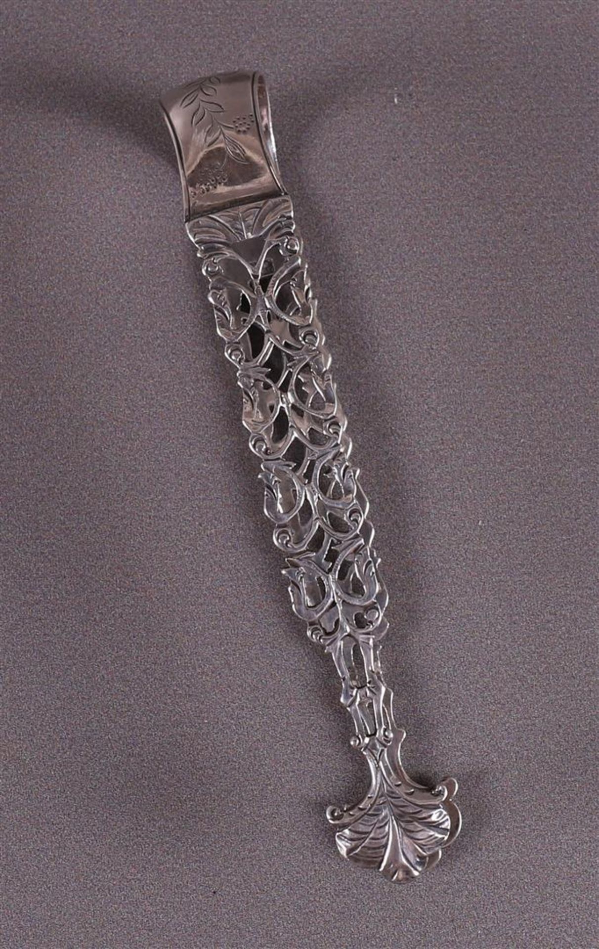 A pierced 2nd grade silver candy tongs with hammered decor.