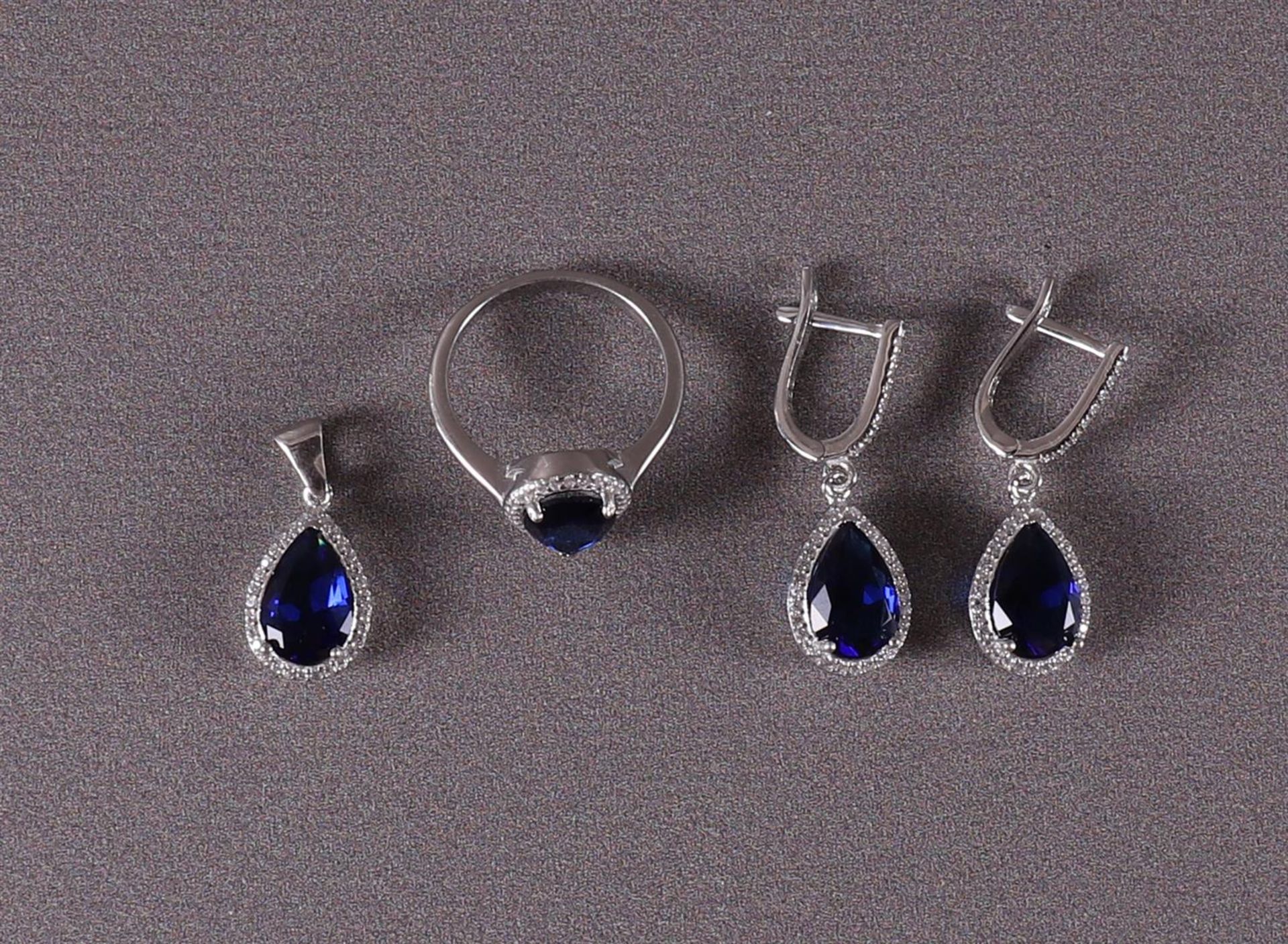 A 1st grade silver ring, earrings and pendant with blue stones