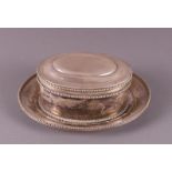A silver oval biscuit tin with a pearl rim, on a matching base.