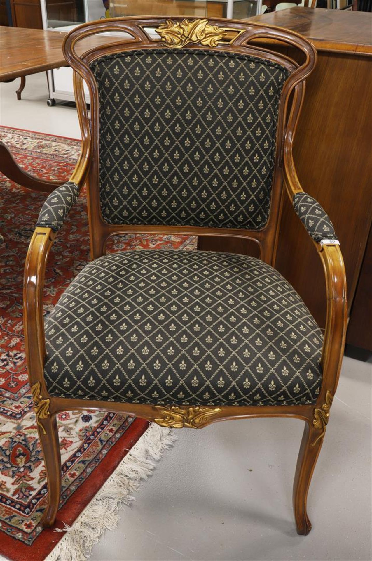 A walnut arm chair with green fabric upholstery, 20th century.