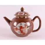 A porcelain teapot with 'rouge de fer' decor of long ledge in a garden on capucine ground, China,