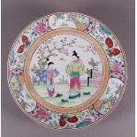 A polychrome porcelain dish, Japan, around 1900. Polychrome decor of figures near a blossom tree,
