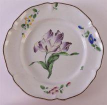 A faience earthenware contoured plate with polychrome decor of a tulip, France, ca. 1750-1780.