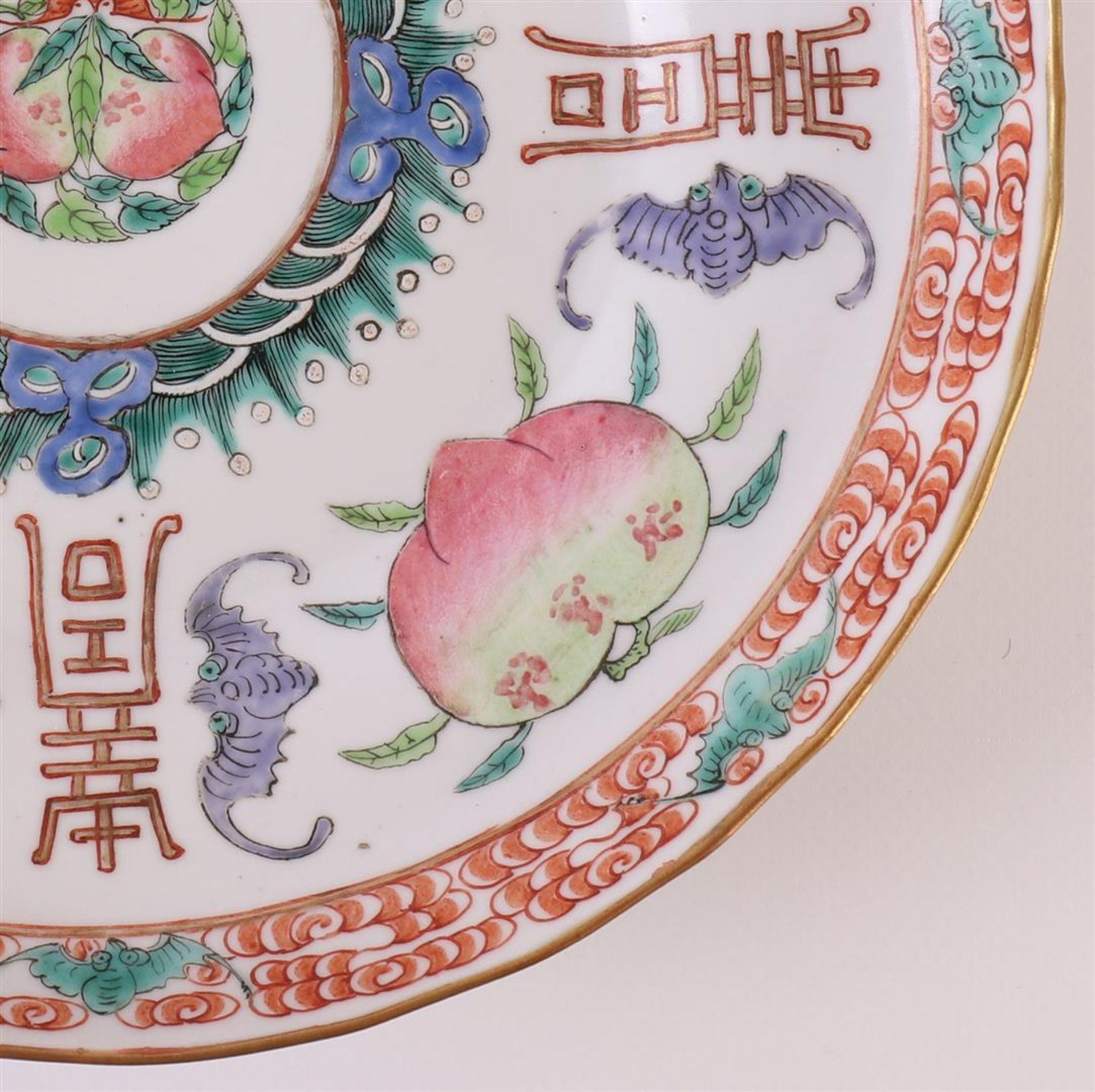 A slightly contoured porcelain dish, Japan, 19th century. Polychrome decor of peaches, bats and - Image 6 of 12