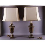 A pair of baluster-shaped bronze lamp bases with cream fabric lampshades, 20th century, h 85 cm,