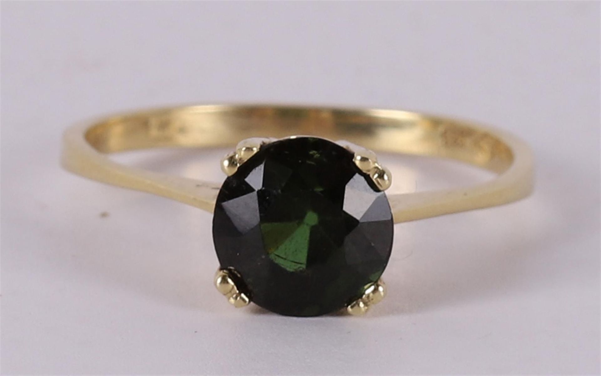 A vintage 14 kt 585/1000 gold solitaire ring with a facet cut green garnet. Ring size 17.5 mm.
