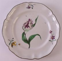 A faience earthenware contoured plate with polychrome decor of a tulip, France, ca. 1750-1780.