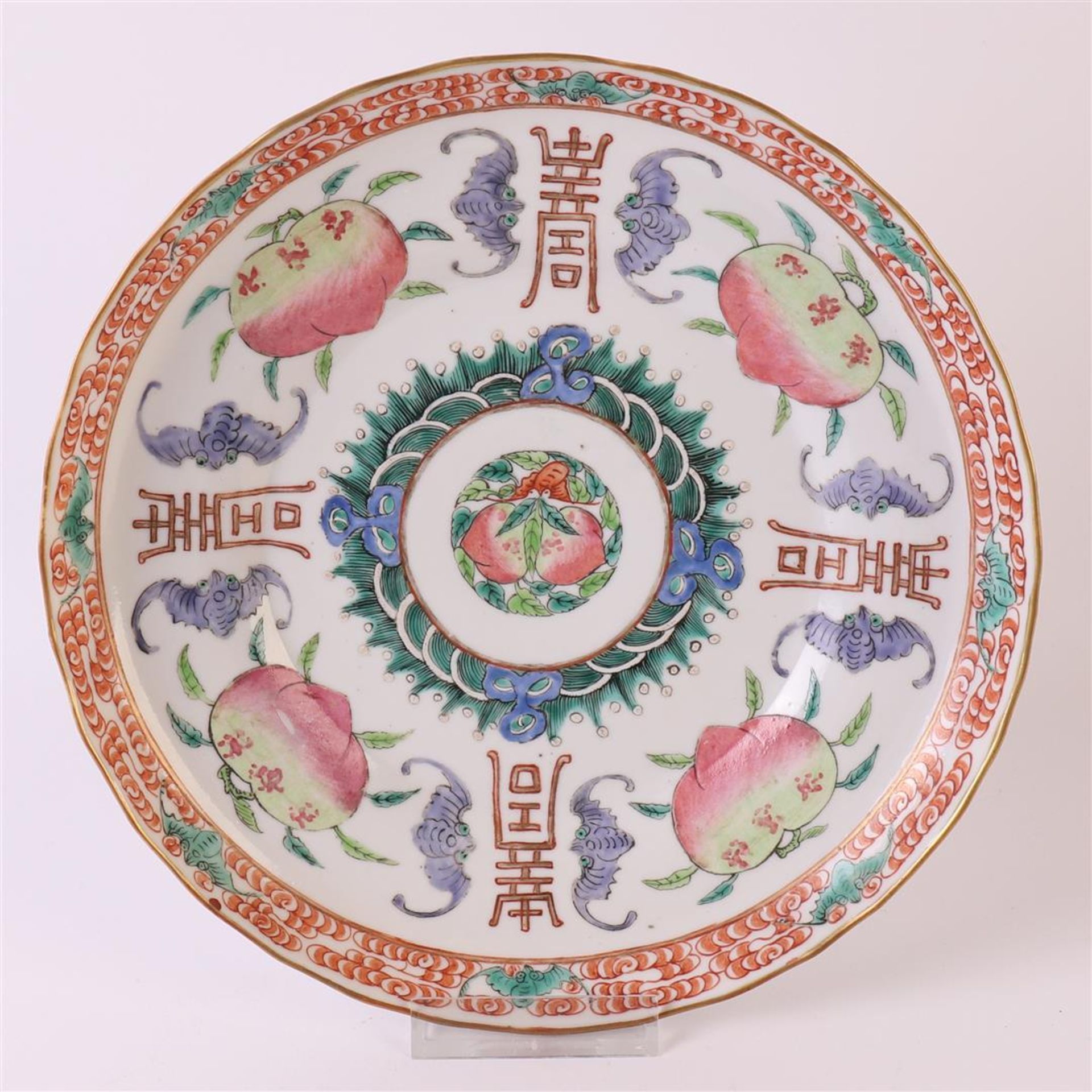 A slightly contoured porcelain dish, Japan, 19th century. Polychrome decor of peaches, bats and