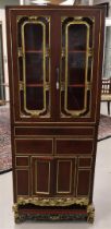 A red lacquer/ebonised gilt two-door display cabinet, China, 20th century. In the lower cabinet
