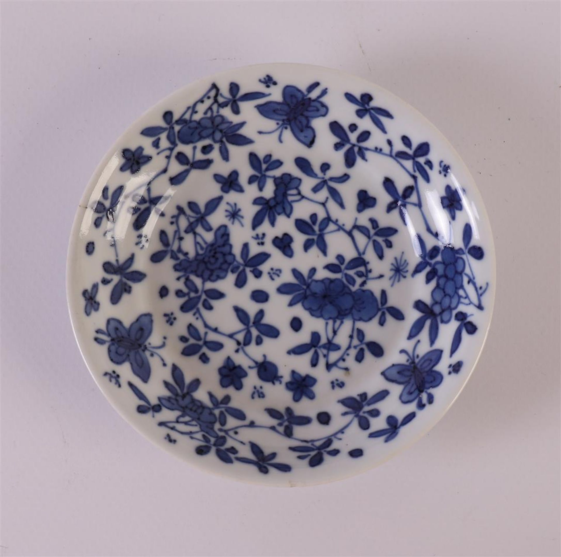 A blue/white porcelain saucer, China, Kangxi, around 1700. Blue underglaze floral decor with