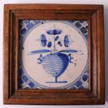 A blue/white earthenware tile depicting flowers in a vase, Holland 19th century. In wooden frame,