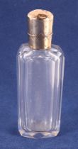 A faceted clear crystal odeur bottle with 14 kt 585/1000 gold lid and frame, around 1900.