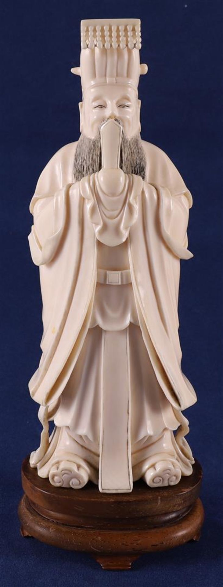 A carved ivory dignitary Lu Dongbin, on wooden base, China, late 19th century, 19 cm, 400 grams. (