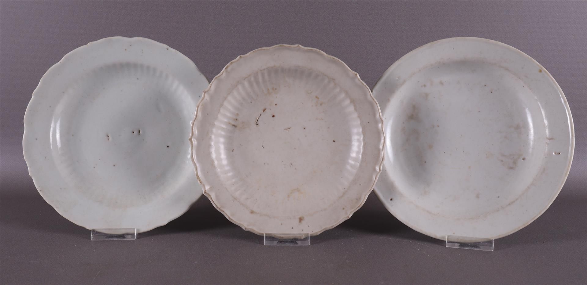 Three various white glazed contoured dishes, China, Song/Ming, Ø 18-19 cm, tot. 3x.