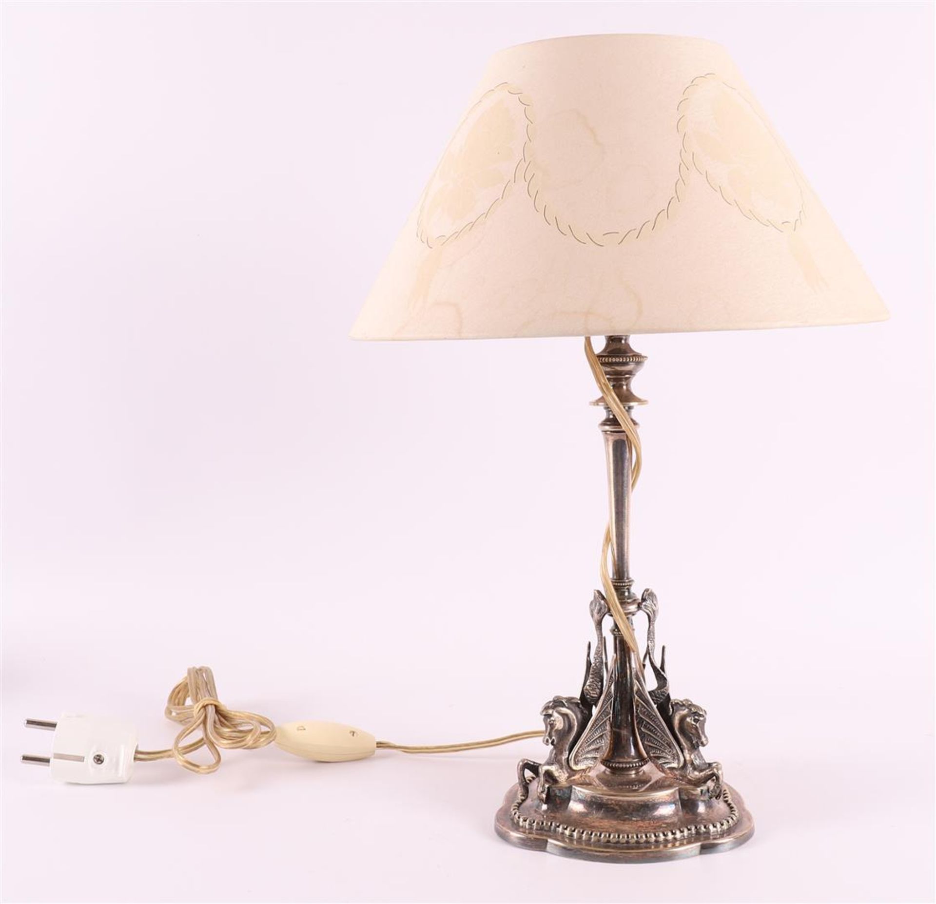A silver plated brass table lamp with conical fabric shade, 20th century. Applications of winged sea