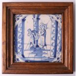 A blue/white earthenware tile with a religious scene, Holland 19th century. In wooden frame, h 13