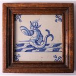 A blue/white earthenware tile depicting a mermaid man, Holland 17th century. In wooden frame, h 13 x
