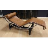 A chrome-plated tubular frame lounge chair, in the style of Le Corbusier. Brown leather upholstery.